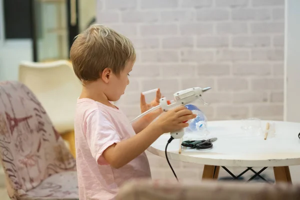 Lakukan sendiri mainan DIY dari botol plastik bahan daur ulang, cangkir menggunakan pistol lem cair panas. Mendukung kreativitas, kerajinan tangan. Kreatif waktu luang untuk anak-anak di dalam ruangan selama karantina rumah shcool — Stok Foto