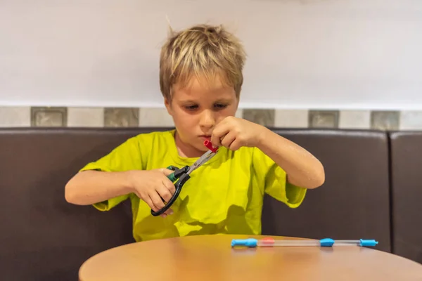 Anak kecil berkaos kuning hijau memotong material daur ulang di kelas seni dan kerajinan di sekolah online membuat hadiah buatan tangan. Pendidikan anak-anak, konsep pembangunan — Stok Foto