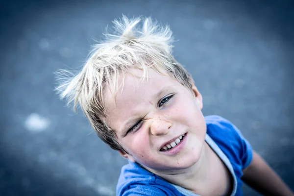 Potret seorang anak laki-laki lucu bahagia nakal berambut pirang dan ceria membuat bintik-bintik wajah kotor saat bermain, tertawa. Anak-anak, bahagia masa kecil, pendidikan, hubungan keluarga konsep — Stok Foto