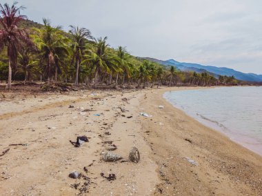 Yere saçılmış bir sürü çöp, sahile yakın deniz atıkları. Çevre felaketi ve kirliliği sorunu. Gezegen ekolojisi. Yetkisiz çöp yığını.