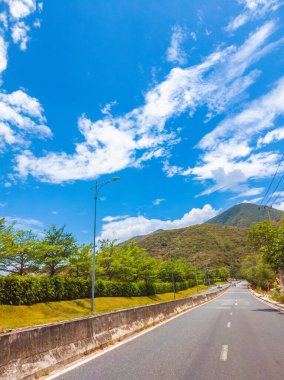 Kuru asfalt boş otomobil yolu beton bariyer ve işaretli çizgiler güneşli bir yaz gününde mavi bulutlu gökyüzü. Araba yolculuğu konsepti. Hikayeler dikey biçimi