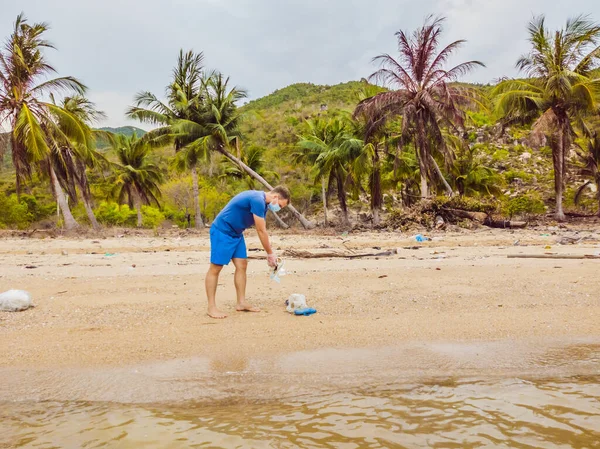 Manusia dalam sarung tangan mengambil kantong plastik yang mencemari laut. Masalah tumpah sampah sampah di pasir pantai disebabkan oleh polusi buatan manusia, kampanye untuk membersihkan diri dalam konsep — Stok Foto