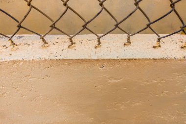Beton bej boyalı duvarın arka planında eski demir tel çit vintage ağı var. Tasarım veya duvar kağıdında kullanmak için alanı kopyala