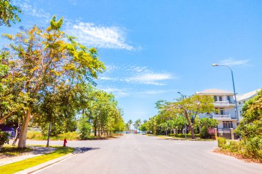 Deniz kenarındaki lüks ve rahat köy manzarası. Boş asfalt yol, güzel hava ve mavi gökyüzü. Tasarım veya duvar kağıdında kullanmak için alanı kopyala