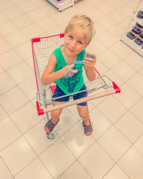 Gelukkig lachend kind zittend in trolley kar plezier hebben — Stockfoto