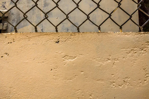 Penutup tua kawat besi pagar jaring vintage di latar belakang beton beige dinding dicat. Salin ruang ideal untuk digunakan dalam desain atau wallpaper — Stok Foto