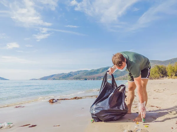 Manusia dalam sarung tangan mengambil plastik yang mencemari laut dan hutan. Masalah tumpah sampah sampah di pasir pantai disebabkan oleh polusi buatan manusia, kampanye untuk membersihkan diri dalam konsep — Stok Foto