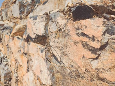 Doğal arka plan. Yakın kenarlı, eski püskü uçurum çatlakları. Dağların gri-kahverengi kaya dokusu. Renkli fotoğrafta eski ve soluk Matt tarzı renkler. Geolog, dağcılık ya da sıkı çalışma kavramı