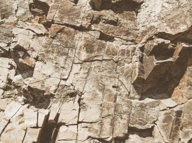 Doğal arka plan. Yakın kenarlı, eski püskü uçurum çatlakları. Dağların gri-kahverengi kaya dokusu. Renkli fotoğrafta eski ve soluk Matt tarzı renkler. Geolog, dağcılık ya da sıkı çalışma kavramı