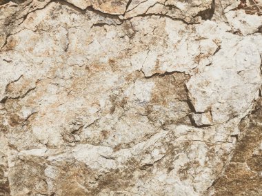 Doğal arka plan. Yakın kenarlı, eski püskü uçurum çatlakları. Dağların gri-kahverengi kaya dokusu. Renkli fotoğrafta eski ve soluk Matt tarzı renkler. Geolog, dağcılık ya da sıkı çalışma kavramı