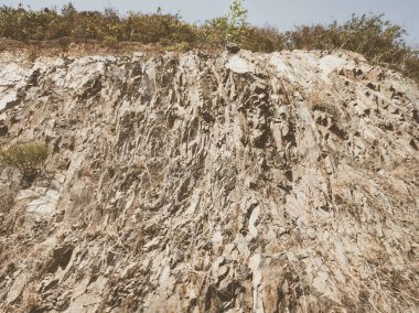 Doğal arka plan. Yakın kenarlı, eski püskü uçurum çatlakları. Dağların gri-kahverengi kaya dokusu. Renkli fotoğrafta eski ve soluk Matt tarzı renkler. Geolog, dağcılık ya da sıkı çalışma kavramı