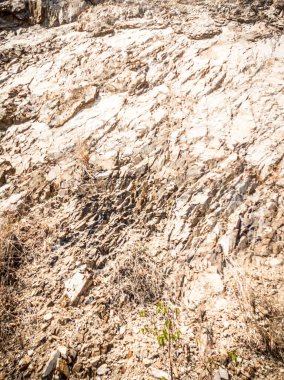 Doğal arka plan. Yakın kenarlı, eski püskü uçurum çatlakları. Dağların gri-kahverengi kaya dokusu. Renkli fotoğrafta eski ve soluk Matt tarzı renkler. Geolog, dağcılık ya da sıkı çalışma kavramı