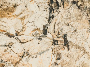 Doğal arka plan. Yakın kenarlı, eski püskü uçurum çatlakları. Dağların gri-kahverengi kaya dokusu. Renkli fotoğrafta eski ve soluk Matt tarzı renkler. Geolog, dağcılık ya da sıkı çalışma kavramı