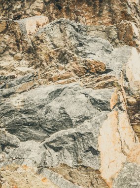 Doğal arka plan. Yakın kenarlı, eski püskü uçurum çatlakları. Dağların gri-kahverengi kaya dokusu. Renkli fotoğrafta eski ve soluk Matt tarzı renkler. Geolog, dağcılık ya da sıkı çalışma kavramı