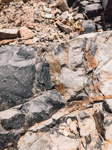 Natuurlijke achtergrond. Nauwkeurige scheuren in de rotswand. Grijs-bruine stenen rotsstructuur van bergen. Vintage en vervaagde matte stijl kleur in getinte foto. Begrip geolog, bergbeklimmen of hard werken — Stockfoto