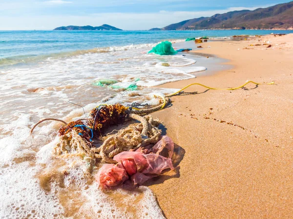Sampah tumpah di pantai. Menggunakan kantong plastik dan tali. Pantai berpasir laut kotor. Polusi lingkungan. Masalah ekologi. Pembuangan Samudra polusi total — Stok Foto