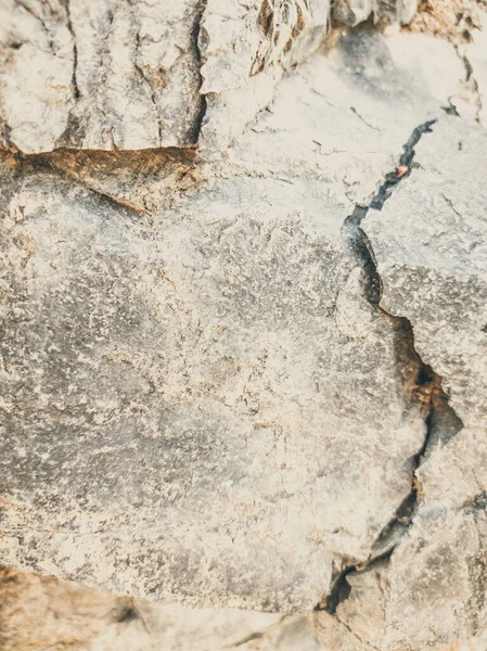 Přirozené pozadí. Úzké, ošuntělé pukliny na útesech. Šedohnědé kamenné skalní útvary hor. Ročník a vybledlá matná barva v zabarvené fotografii. Koncept geolog, horolezectví nebo tvrdé práce — Stock fotografie