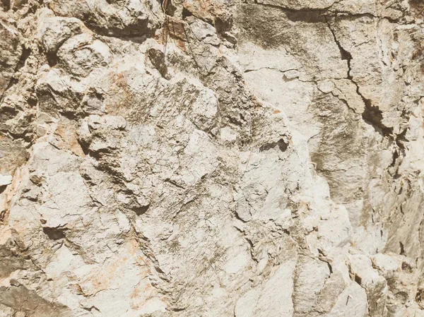 Natuurlijke achtergrond. Nauwkeurige scheuren in de rotswand. Grijs-bruine stenen rotsstructuur van bergen. Vintage en vervaagde matte stijl kleur in getinte foto. Begrip geolog, bergbeklimmen of hard werken — Stockfoto