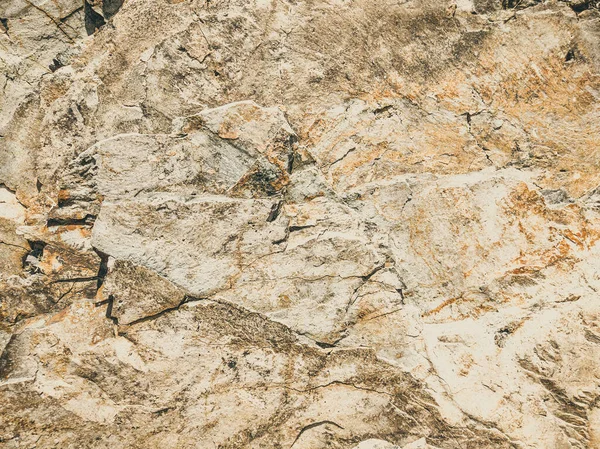 Natuurlijke achtergrond. Nauwkeurige scheuren in de rotswand. Grijs-bruine stenen rotsstructuur van bergen. Vintage en vervaagde matte stijl kleur in getinte foto. Begrip geolog, bergbeklimmen of hard werken — Stockfoto