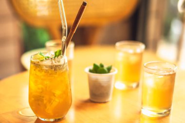 Sağlıklı sarı içecek limonata, meyve buzlu kombu çayı, yeşil Chia tohumu çayı yeniden kullanılabilir cam pipetle ahşap masada. Güneş parıltısı fotoğrafı. Restoran sağlıklı içecekler veya yaz buluşması konsepti.