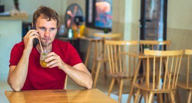 Şaşırdım, korkmuş Kafkasyalı genç adam kafede kırmızı gömlekli akıllı telefona cevap veriyor, bardaktan yapılmış çayını içiyor ya da iş birliği yapıyor. Gerçek insanlar ifade eder, hayat sorunları çözer, iletişim kurar, ilişki kurar