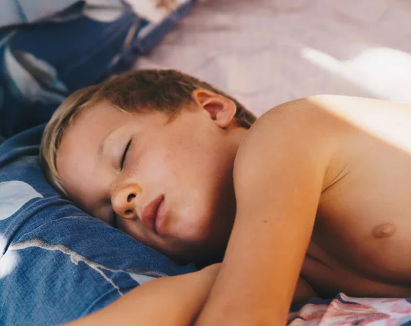 Anak kecil yang lucu tidur manis di atas bantal dengan sinar matahari pagi yang cerah dari jendela, tidur siang. Selamat tidur untuk anak-anak. Masalah kebangkitan dini, keterlambatan tertidur, kesehatan bioritme tidur — Stok Foto