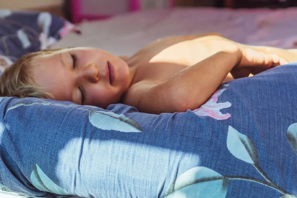 Anak kecil yang lucu tidur manis di atas bantal dengan sinar matahari pagi yang cerah dari jendela, tidur siang. Selamat tidur untuk anak-anak. Masalah kebangkitan dini, keterlambatan tertidur, kesehatan bioritme tidur — Stok Foto