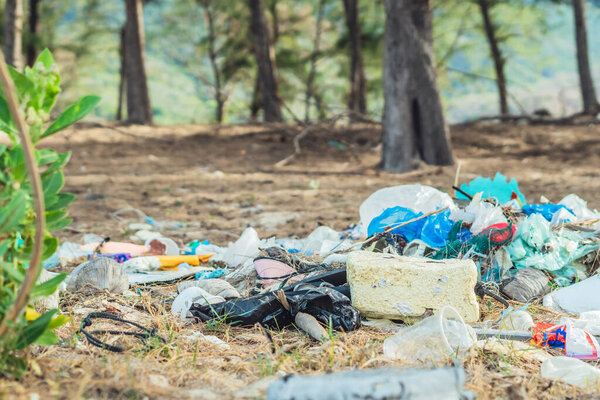 Spilled recycling garbage in park forest. Empty used dirty waste plastic bottles and carton paper boxes. Environmental total pollution, ecological problem, global warming, people dont care