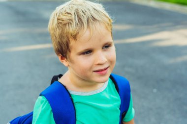 Komik, yaramaz, sarışın, çilli, mavi sırt çantalı, okul ya da anaokulundan kalma, sanatsal duyguları olan, yüz ifadesi olan bir çocuk. Mikro anlar basit sevinçler mutlu çocukluk, eğitim sorunları psikoloji