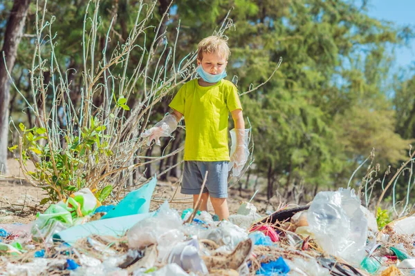 Anak sukarelawan bertopeng wajah membantu memungut sampah yang mencemari pantai dekat hutan. Masalah tumpah sampah planet sampah polusi konsep perlindungan lingkungan. Pendidikan anak alami — Stok Foto