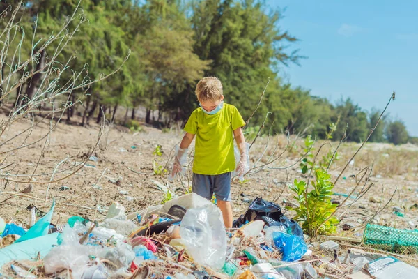 Anak sukarelawan bertopeng wajah membantu memungut sampah yang mencemari pantai dekat hutan. Masalah tumpah sampah planet sampah polusi konsep perlindungan lingkungan. Pendidikan anak alami — Stok Foto