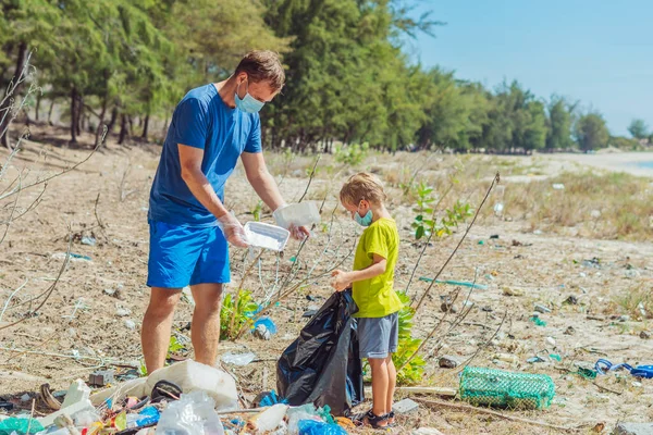 Sukarelawan bertopeng wajah biru. Ayah, anak mengambil sampah yang mencemari pantai dekat laut lazur. Masalah tumpah sampah planet sampah polusi perlindungan lingkungan. Pendidikan anak alami — Stok Foto