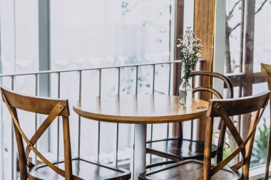 İkinci dalga Coronavirus şehri karantinası sırasında insanların kafeterya restoranındaki mobilya dekorasyonu eski moda. Güneşli bir günde tahta masalar ve sandalyeler. Kafenin iç tasarımı.