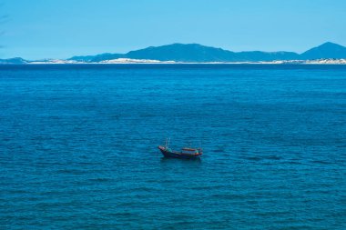 Saf mavi gök mavisi denizdeki güzel manzara, berrak gökyüzü, dağ adası arkaplanı, boş denizde bir tekne yüzdürmek. Duvar kağıdı tasarımı için. Yaz tatilinin ardından turizm eğlencesi
