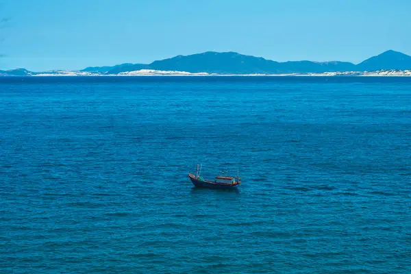 Saf mavi gök mavisi denizdeki güzel manzara, berrak gökyüzü, dağ adası arkaplanı, boş denizde bir tekne yüzdürmek. Duvar kağıdı tasarımı için. Yaz tatilinin ardından turizm eğlencesi