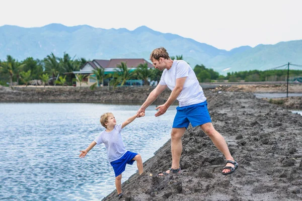 Ayah membantu anak pergi ke danau air, menjelaskan aturan keselamatan. Keluarga bersama-sama berjalan bermain. Pendidikan anak alami di rumah, hari ayah, tanggung jawab ayah, mempengaruhi pembentukan pandangan anak terhadap dunia — Stok Foto