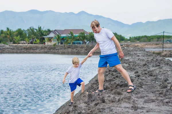 Ayah membantu anak pergi ke danau air, menjelaskan aturan keselamatan. Keluarga bersama-sama berjalan bermain. Pendidikan anak alami di rumah, hari ayah, tanggung jawab ayah, mempengaruhi pembentukan pandangan anak terhadap dunia — Stok Foto