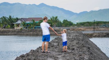 Baba oğul dağ gölünün yanında yürüyor, birbirine bakıyor, göz kırpıyor. Mutlu bir çocukluk. Evde doğal çocuk eğitimi, babalar günü, baba sorumlulukları, oğul dünya görüşü düzeni üzerindeki etkisi.