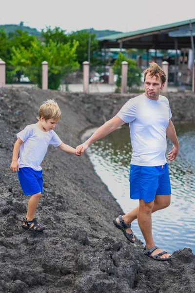 Ayah merawat anak saat berjalan di dekat danau gunung memegang memimpin dengan tangan. Masa kecil yang bahagia. Pendidikan alam rumah, hari ayah, tanggung jawab ayah, pengaruh pada pembentukan pandangan anak terhadap dunia — Stok Foto