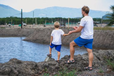 Baba ve oğul, balık gölü arka planında çiftleşen insanlar boyunca yürür. Mutlu bir çocukluk. Evde doğal çocuk eğitimi, babalar günü, baba sorumlulukları, oğul dünya görüşü düzeni üzerindeki etkisi.