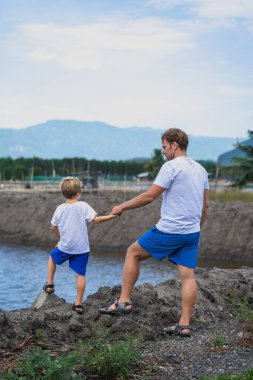 Baba ve oğul, balık gölü arka planında çiftleşen insanlar boyunca yürür. Mutlu bir çocukluk. Evde doğal çocuk eğitimi, babalar günü, baba sorumlulukları, oğul dünya görüşü düzeni üzerindeki etkisi.
