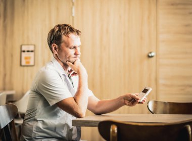 Genç ciddi erkek doktor alternatif tıp olarak biyolojik rezonans tedavisini kullanmayı düşünüyor, küçük taşınabilir yaşam dengesi cihazına bakarak solucan istilasını tedavi etmek için