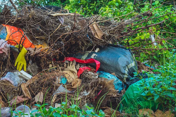 Tukang daur ulang yang tertumpah membuat sampah di hutan dekat kota. Kosong digunakan limbah kotor botol plastik tutup tas dan kotak kertas karton. Polusi total lingkungan, masalah ekologi, pemanasan global — Stok Foto