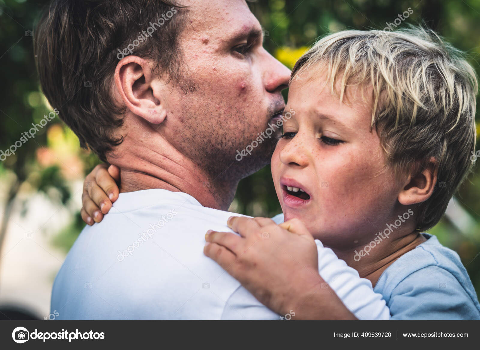 Closeup Sad young blond boy crying on father hands in nature park ...