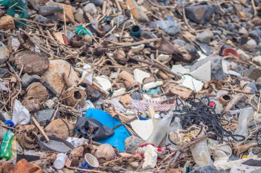 Deniz kıyısındaki taşlara dökülen çöpler gri çakıllar. Kullanılmış kirli plastik şişeler. Çevre kirliliği, ekolojik sorun. Soyut Bileşik Doku Özellikli Web Tasarımı