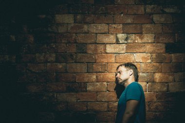 Sol tarafta kriz var. Başını kahverengi duvara dayamış, yorgun görünüyor. Tırmanmak, engelleri aşmak, hedefe ulaşmak, lider, motivasyon.