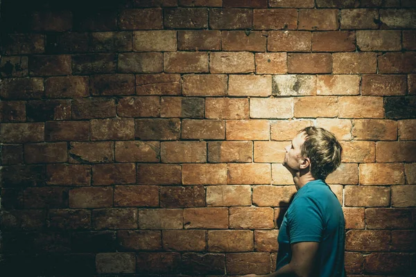 Side view man onder leven crisis problemen staan te kijken op bruine bakstenen muur links boven hoek, wil klimmen, overwinnen hindernis, bereiken van een doel, leider, motivatie — Stockfoto