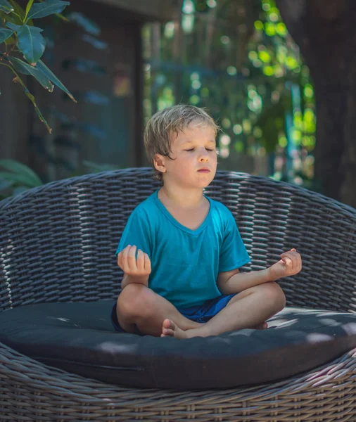 Calma menino do sexo masculino sentar-se no sofá fora jardim praticar ioga. O resto de criança moderno da geração jovem alivia emoções negativas com olhos fechados na pose de lótus no amanhecer. Conceito de meditação Mindfulness — Fotografia de Stock