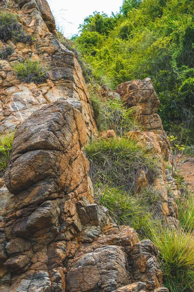 Dari dekat terlihat batu kuning coklat cerah berwarna jingga yang lusuh tebing retak tekstur pegunungan. Konsep geologi, kekuatan kecantikan di alam. Desain latar belakang komposisi musim panas alami — Stok Foto