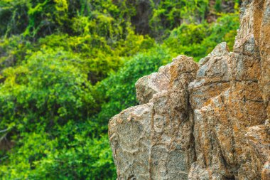Güzel doğal yazlık kompozisyon tarihi arka plan. Parlak turuncu, kahverengi, sarı taştan, pejmürde kayalar doku dağlarını çatlatıyor. Geolog kavramı, deniz turizmi seyahati, doğanın gücü.
